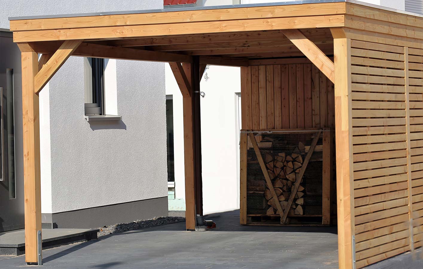 modernes Carport aus Holz an einem weißen Haus