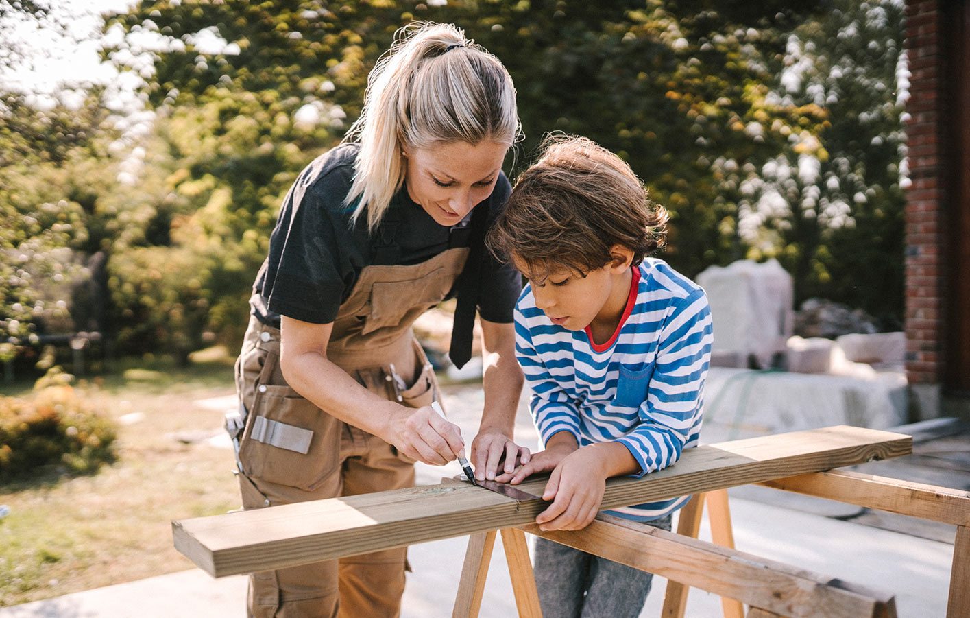 Mutter und Sohn bauen zusammen mit Holz